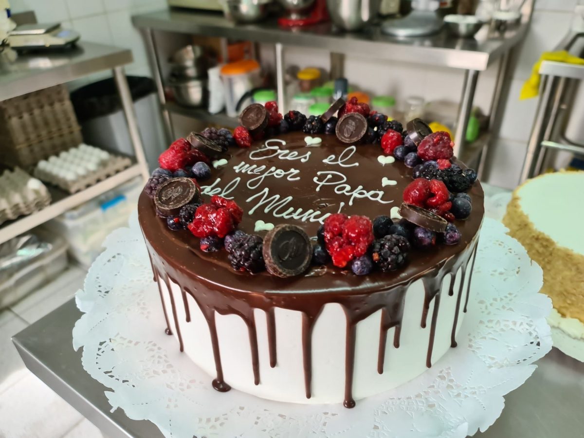 Torta blanca con cobertura de chocolate, frutos rojos y el mensaje Eres el mejor papá del mundo